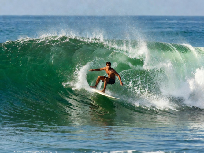 Surfer executing clean bottom turn on green wave